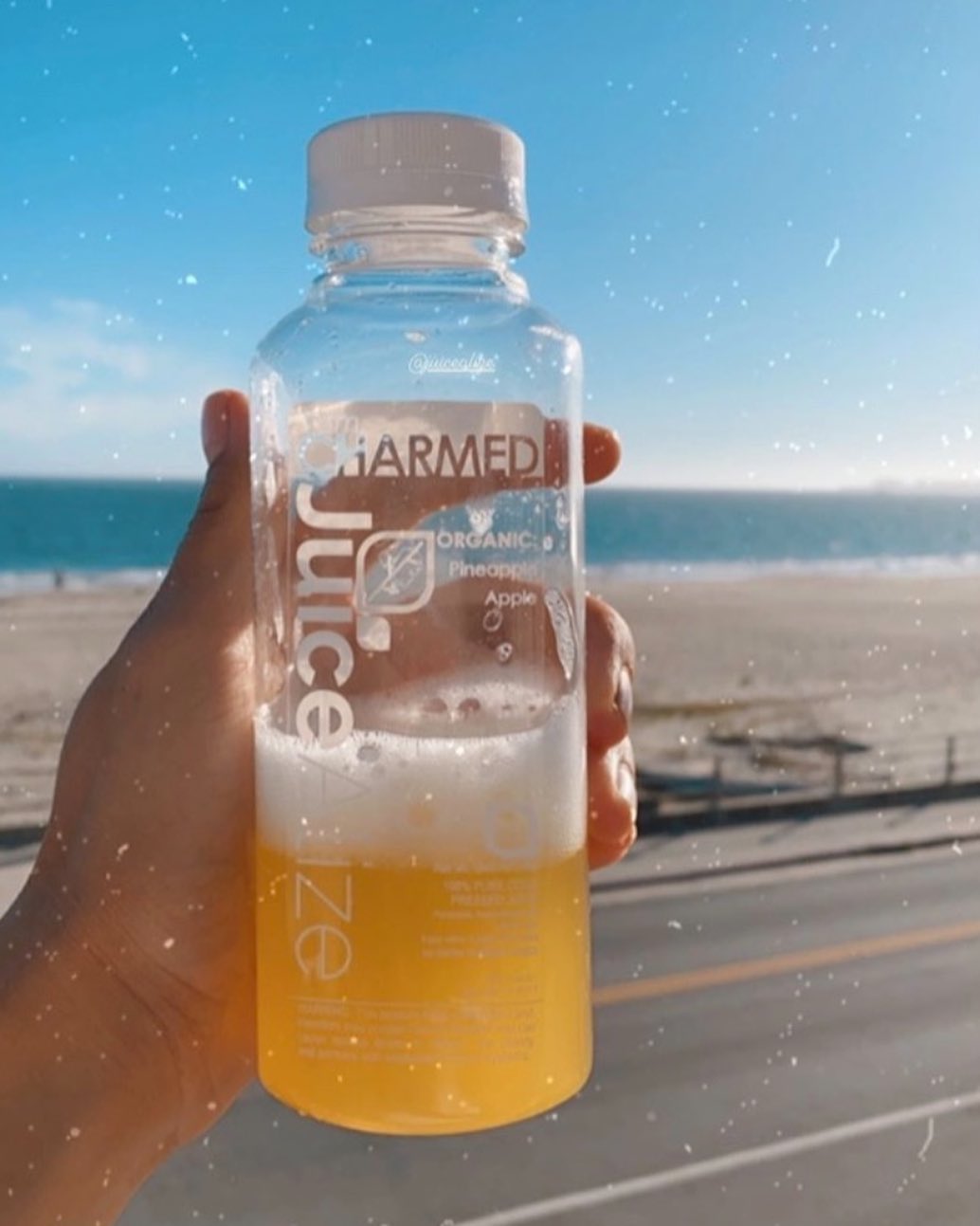 i am CHARMED pineapple apple juice held up at the beach